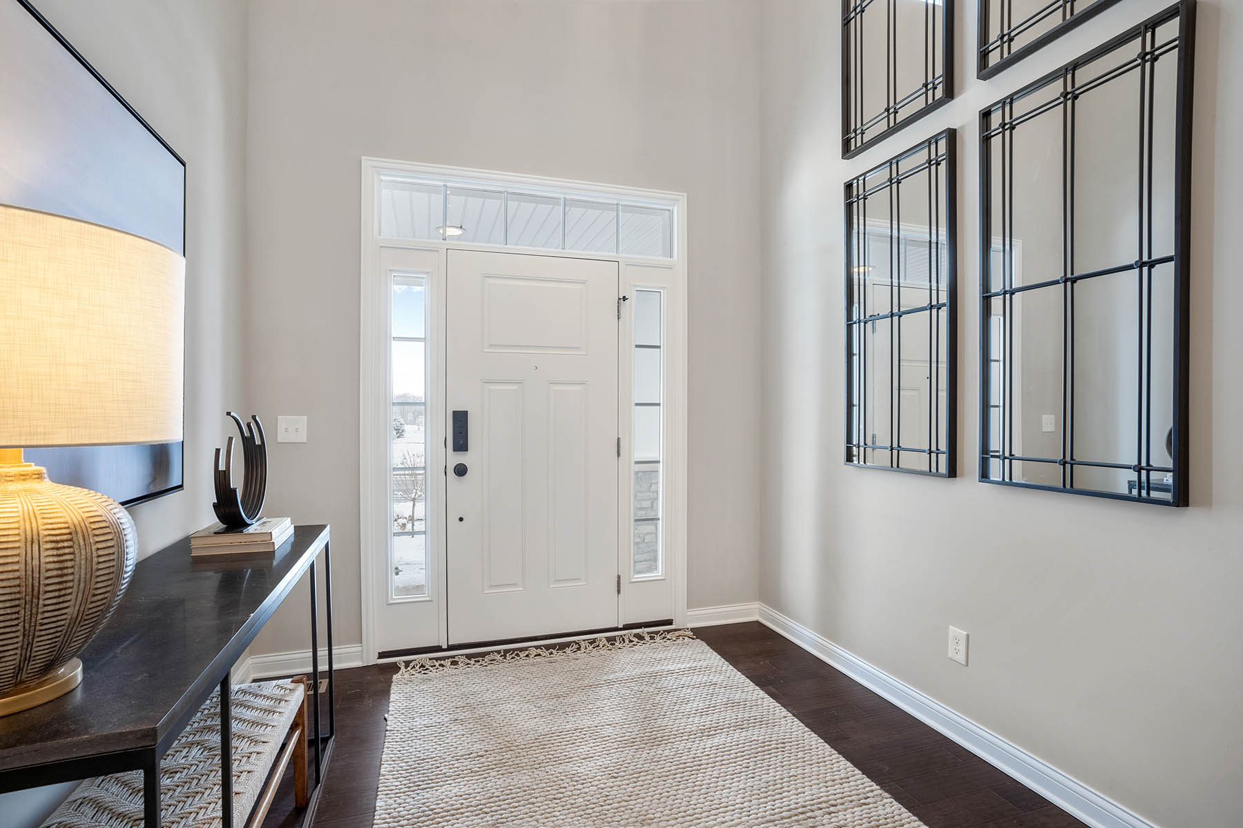 Entryway foyer with 4 large rectangular mirrors hanging on wall