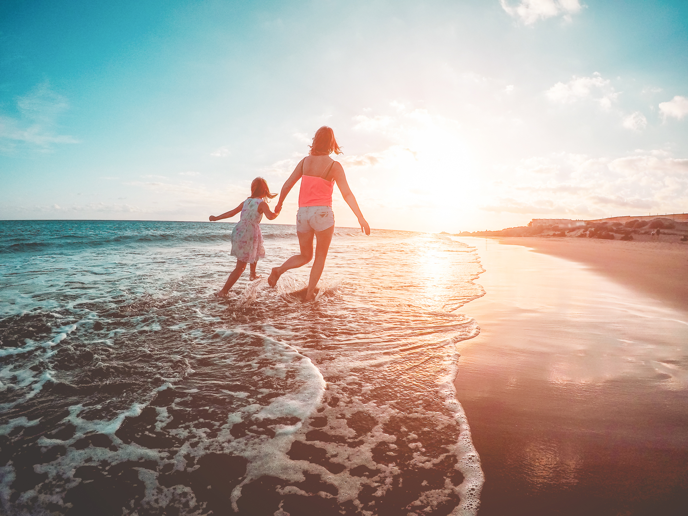 Mother and Child Running on Beach