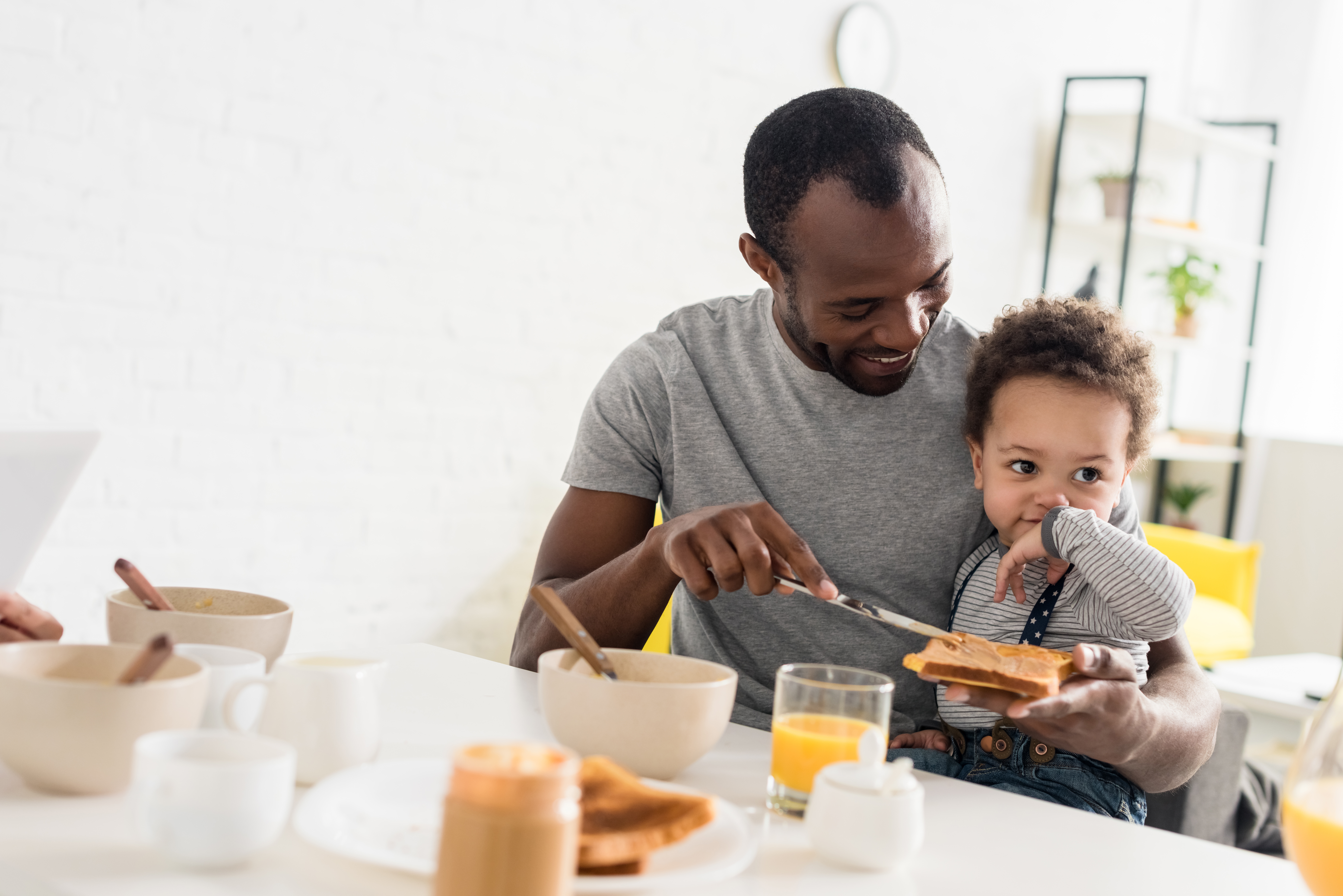 Father and Baby Eating Breakfast at Home