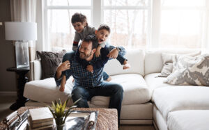 Father and sons playing on couch