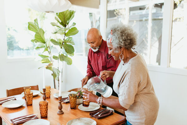 Older Couple Setting a Dining Room Table