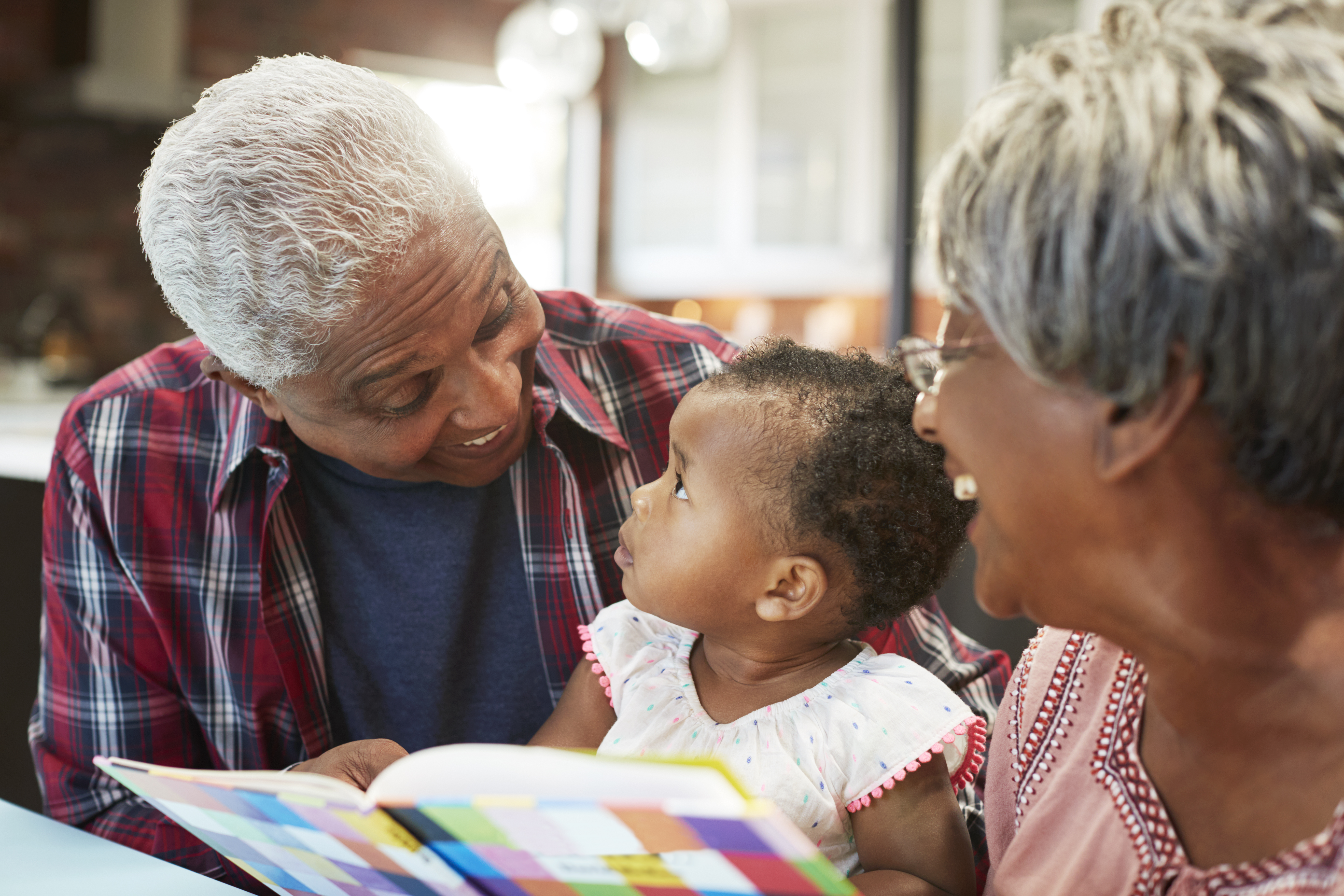 Grandparents Reading Book to Baby