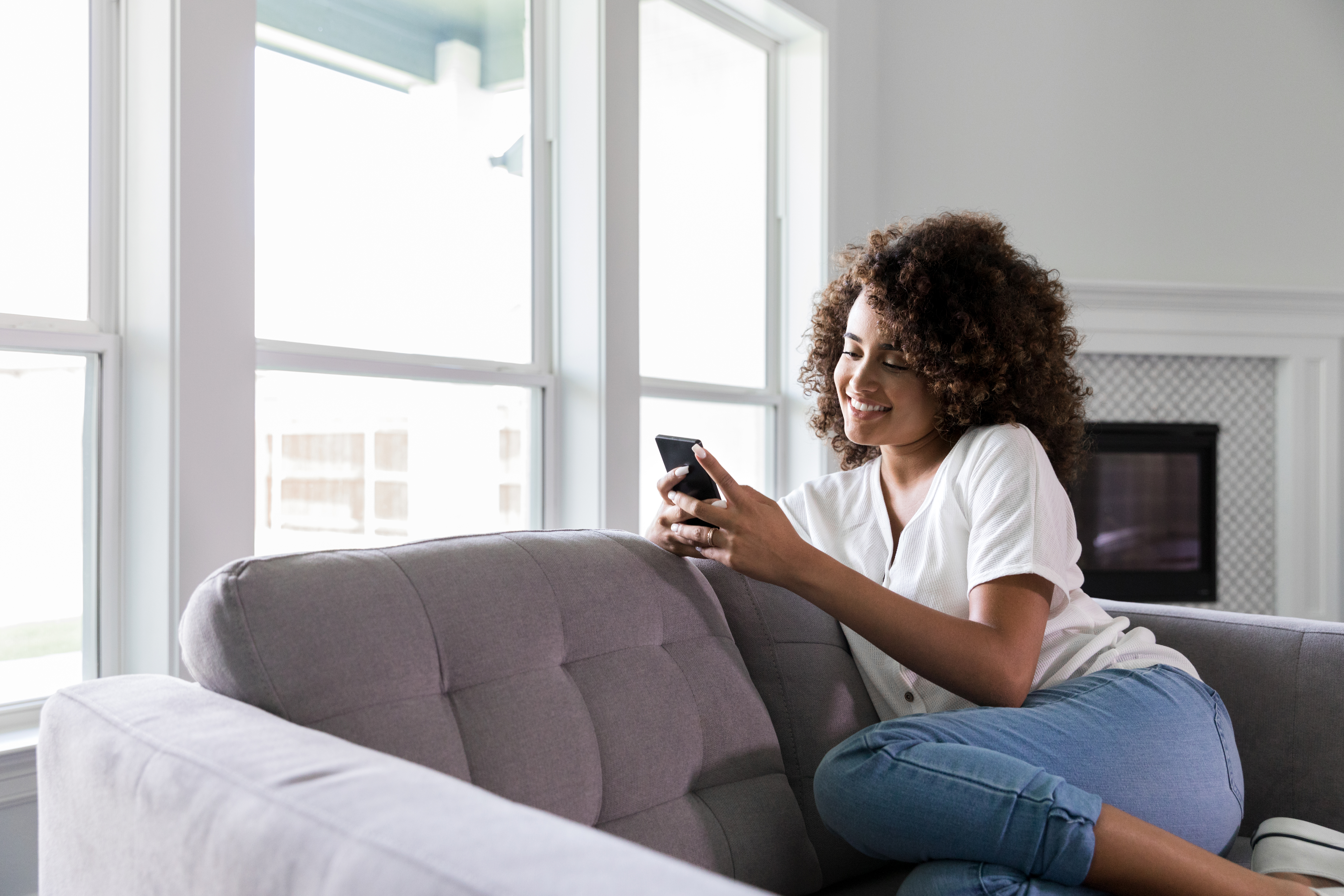 Woman Looking at Phone on Couch