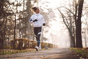 Woman jogging in a park in autumn