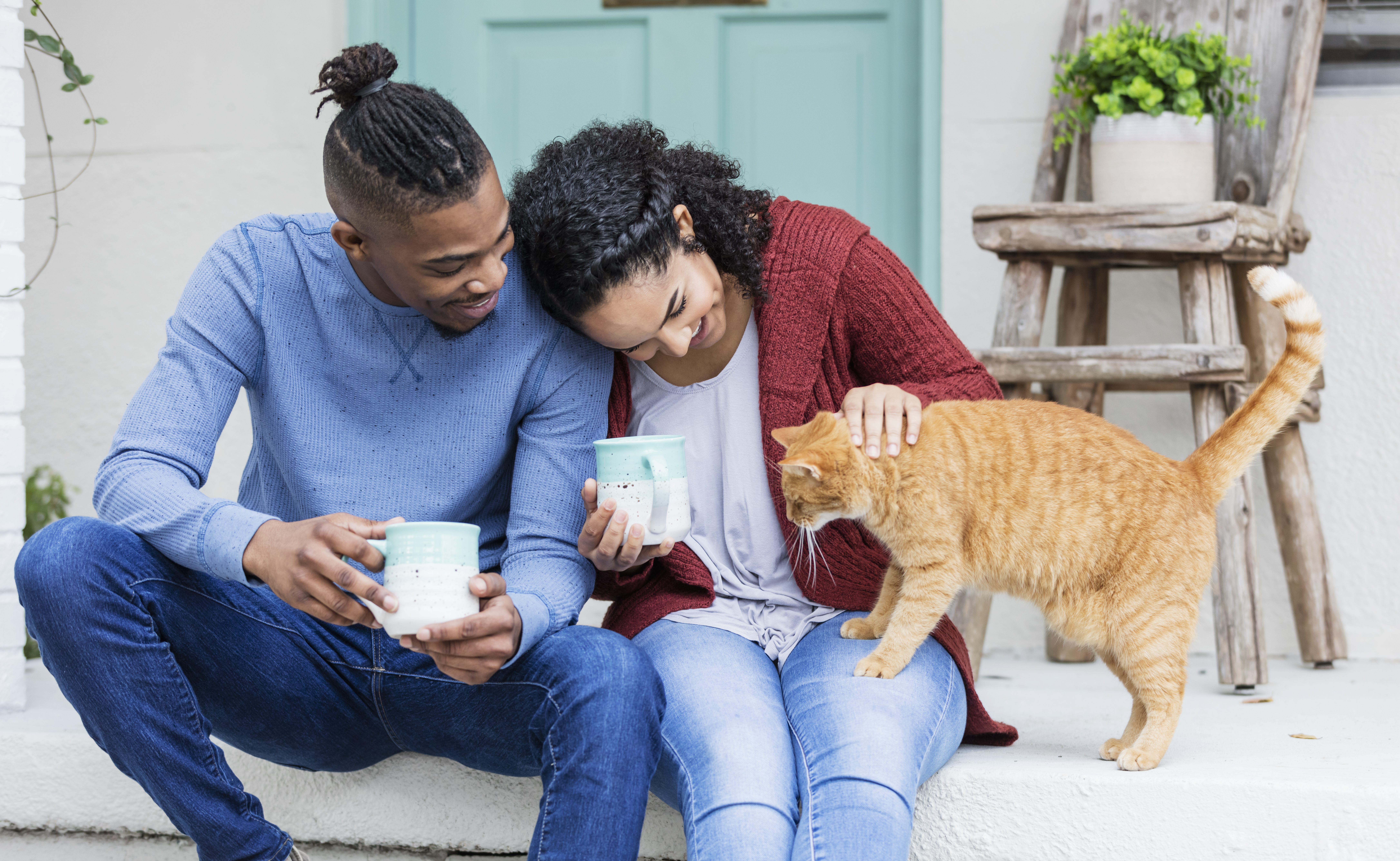 Couple Playing With Cat on Front Porch With Antique Décor