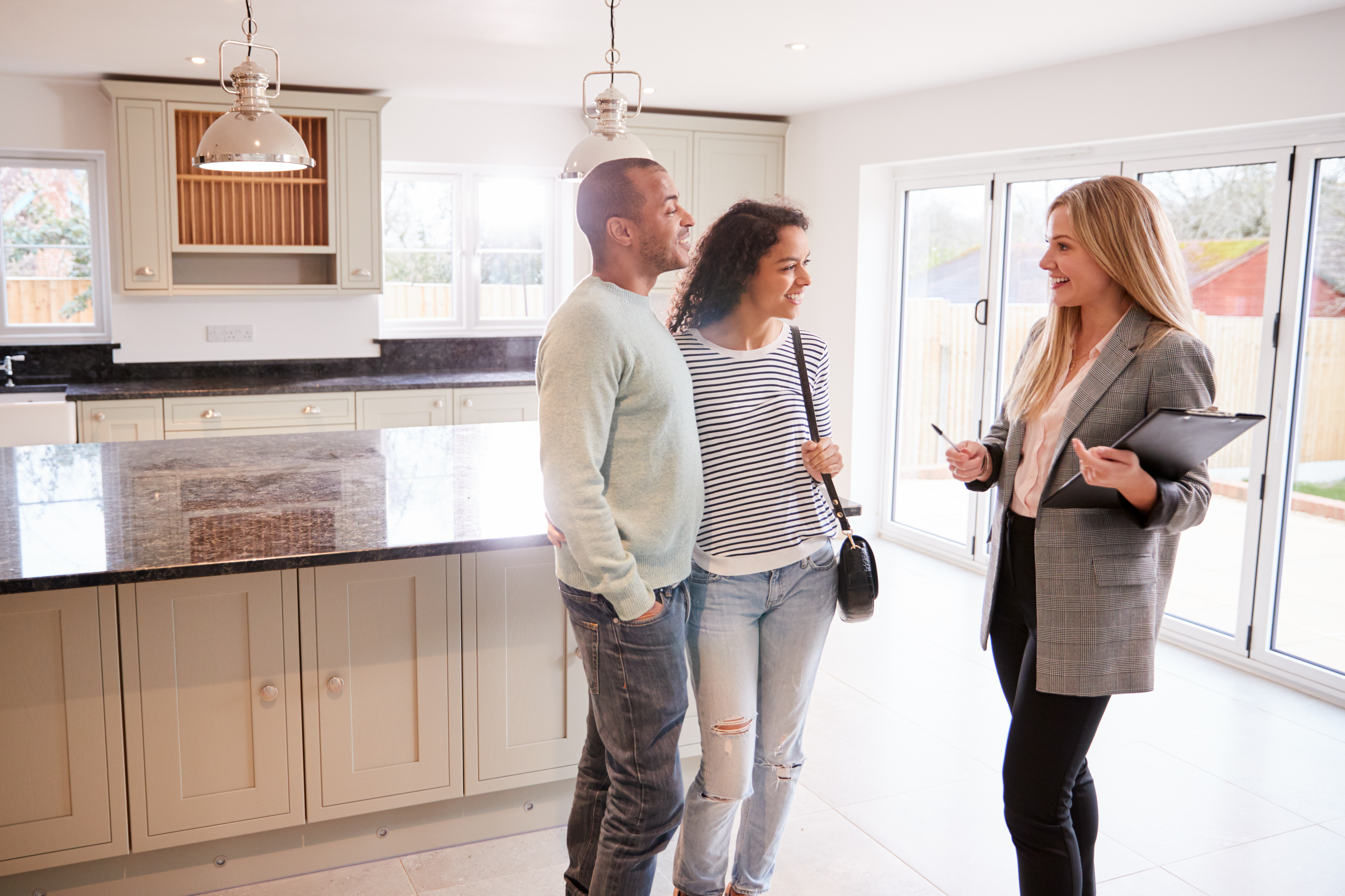 [Couple talking with a new home consultant inside a home]