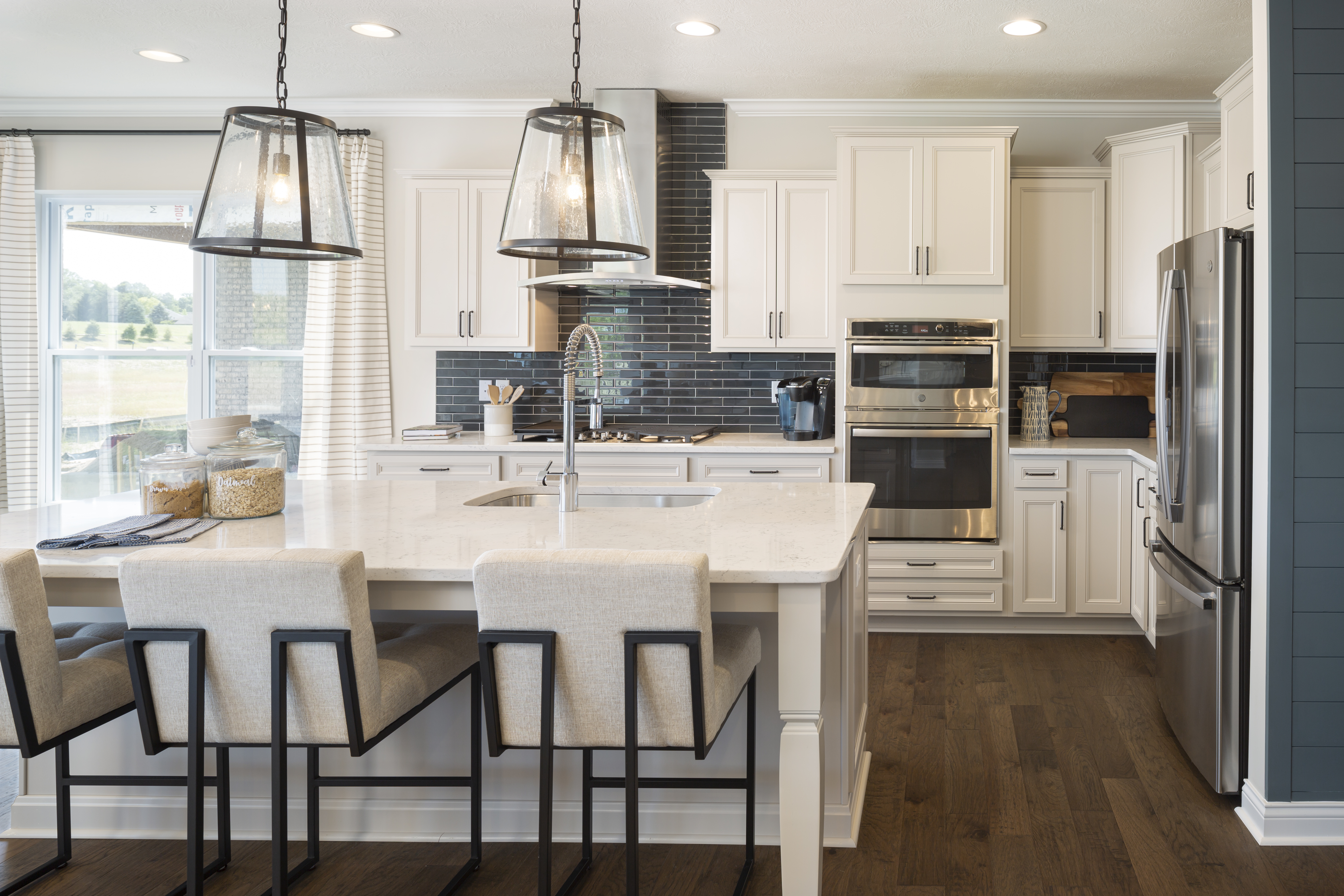 Kitchen With Dark Backsplash and White Cabinets