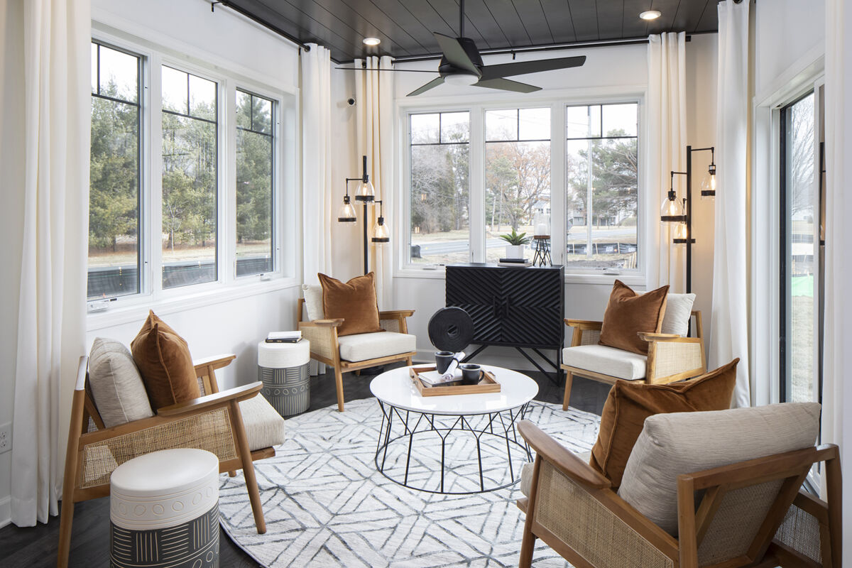 Photo of a decorated morning room with matte black design features, 4 chairs, and a coffee table