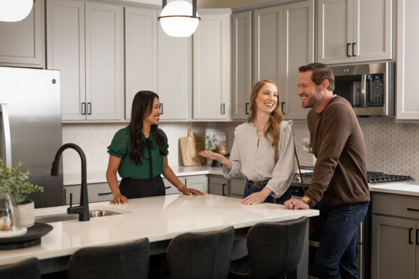 Image of a couple talking with a new home consultant in a model home kitchen