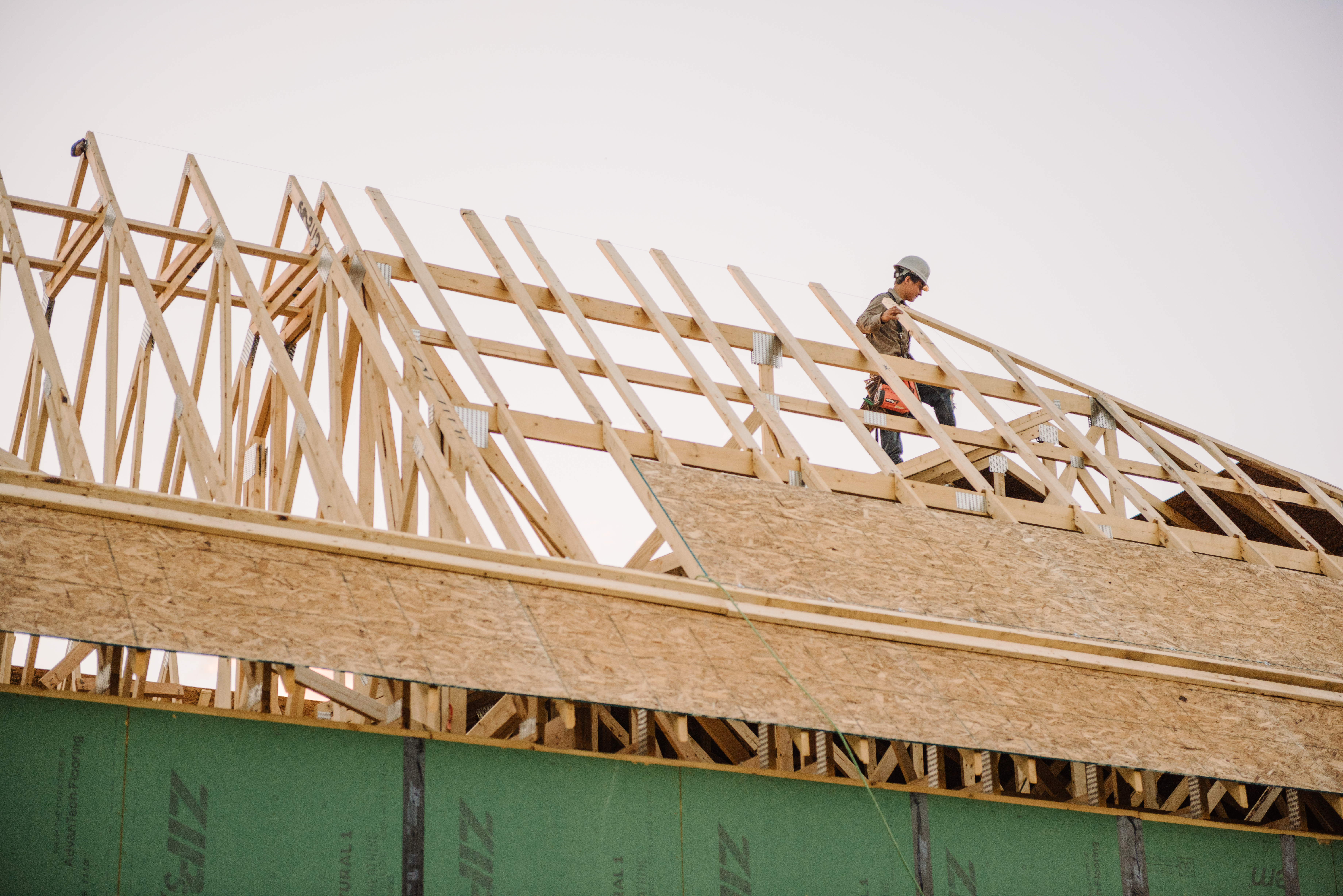 Construction Worker Installing Roof on Home