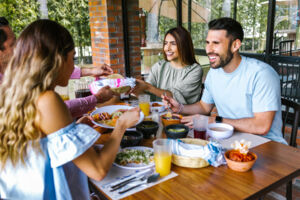 Latin friend group eating around a table