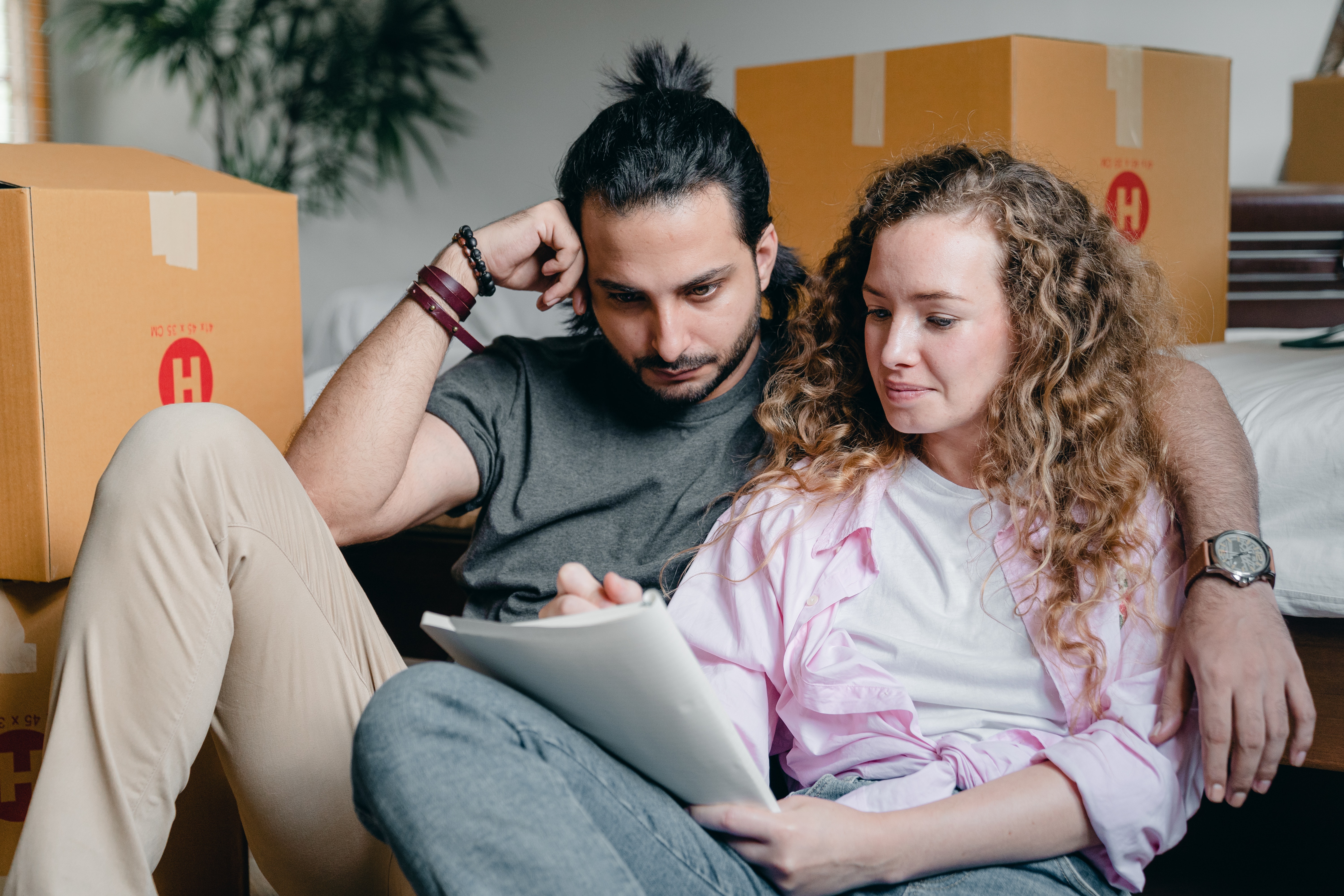 Homebuyers Making a List With Moving Boxes