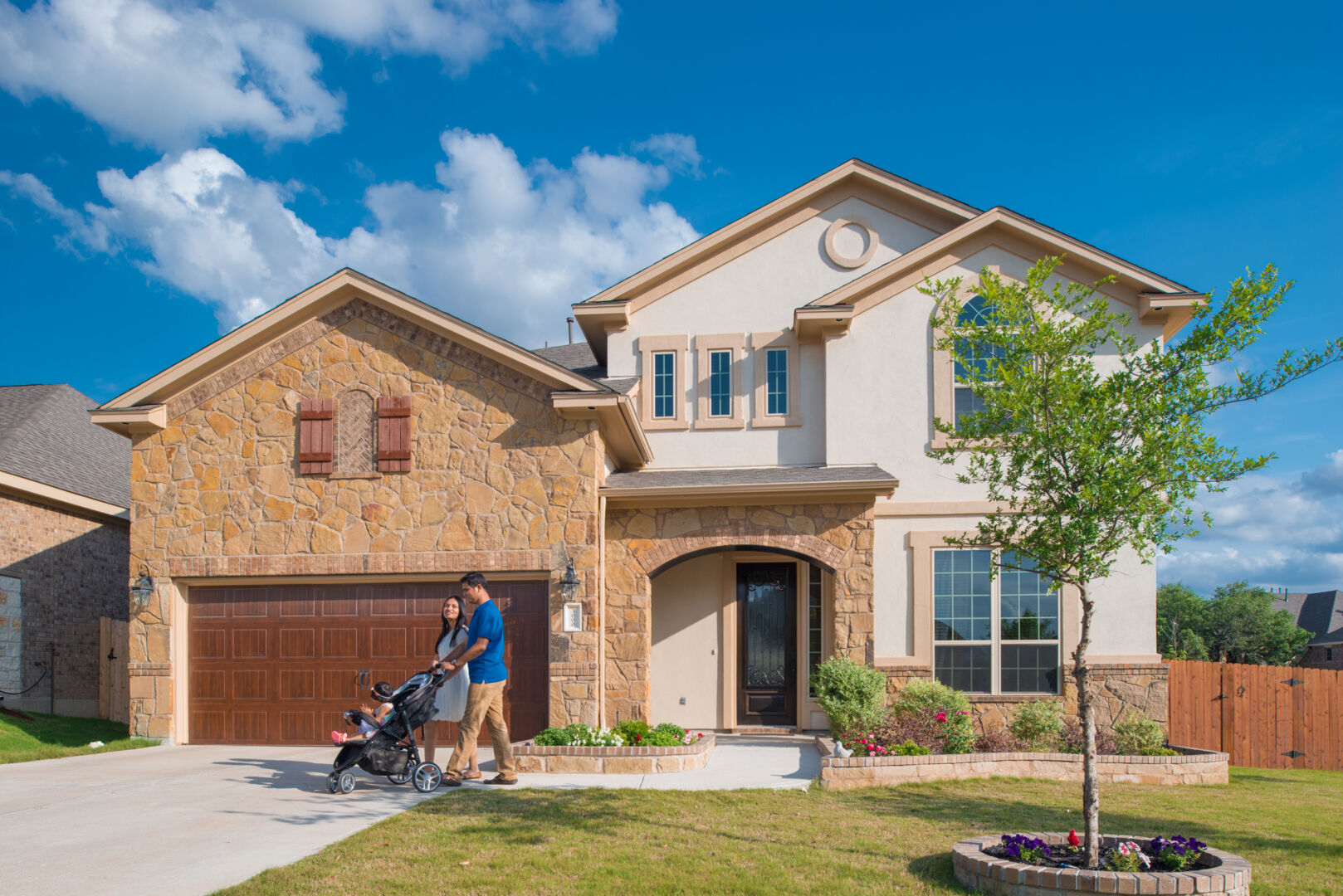 Couple in front of a house pushing a stroller