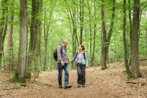Older couple walking on trail in woods