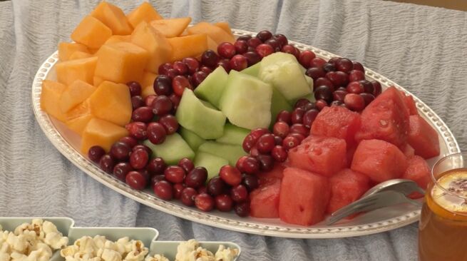 Up-close photo of a fruit tray with melon and cranberries