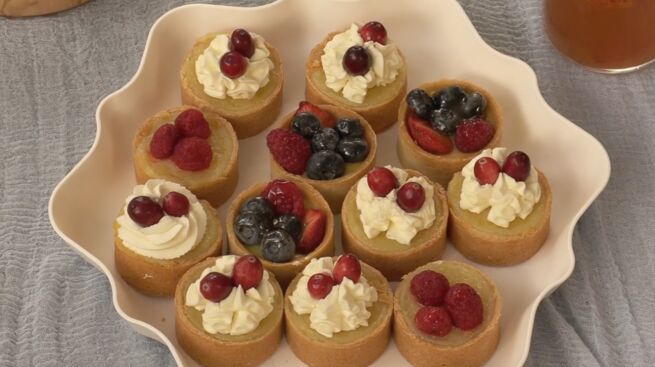 Photo of a plate with several mini key lime pies with fruit and whipped cream on top