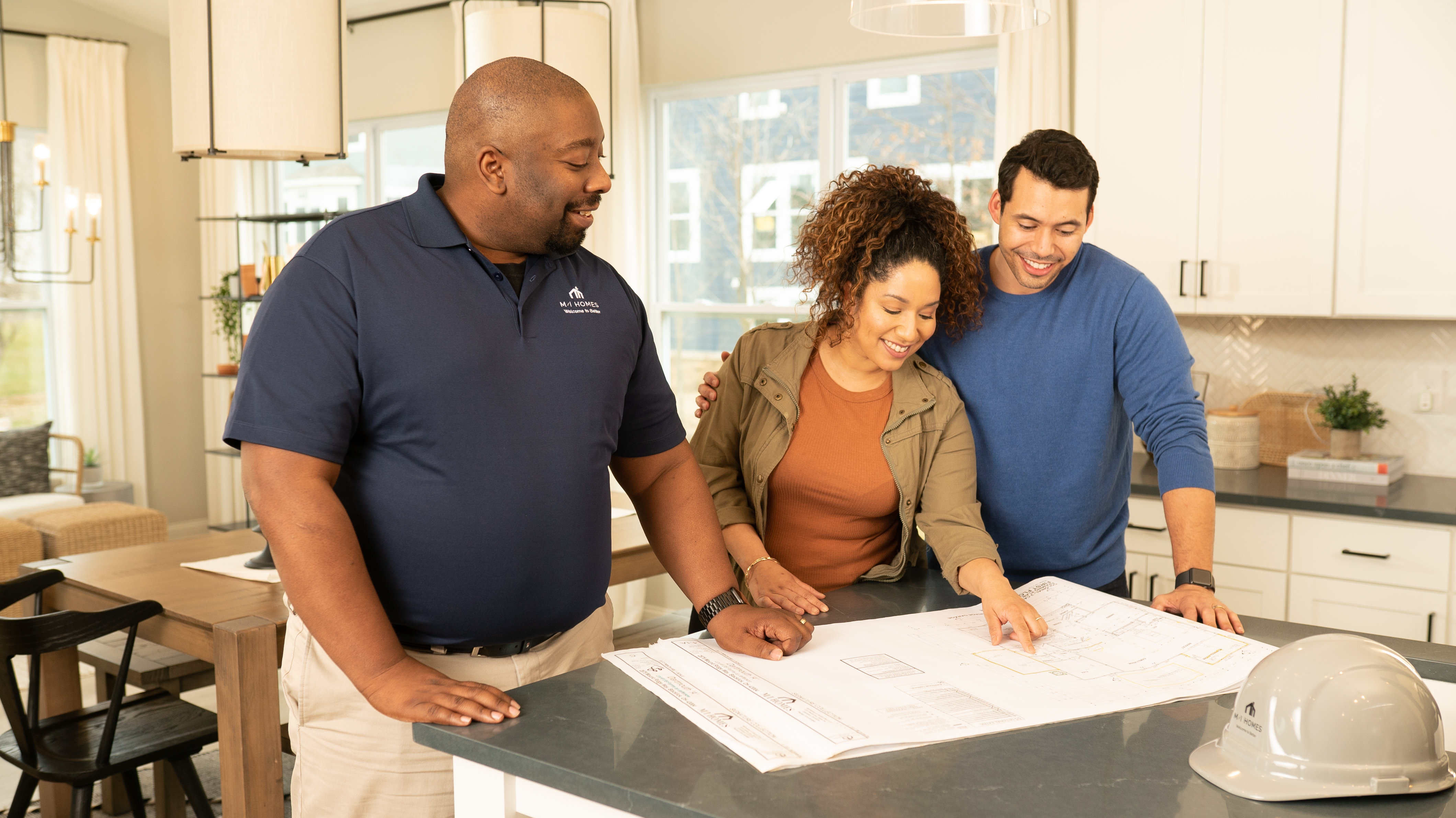 Construction Employee Looking at Floorplans With a Couple