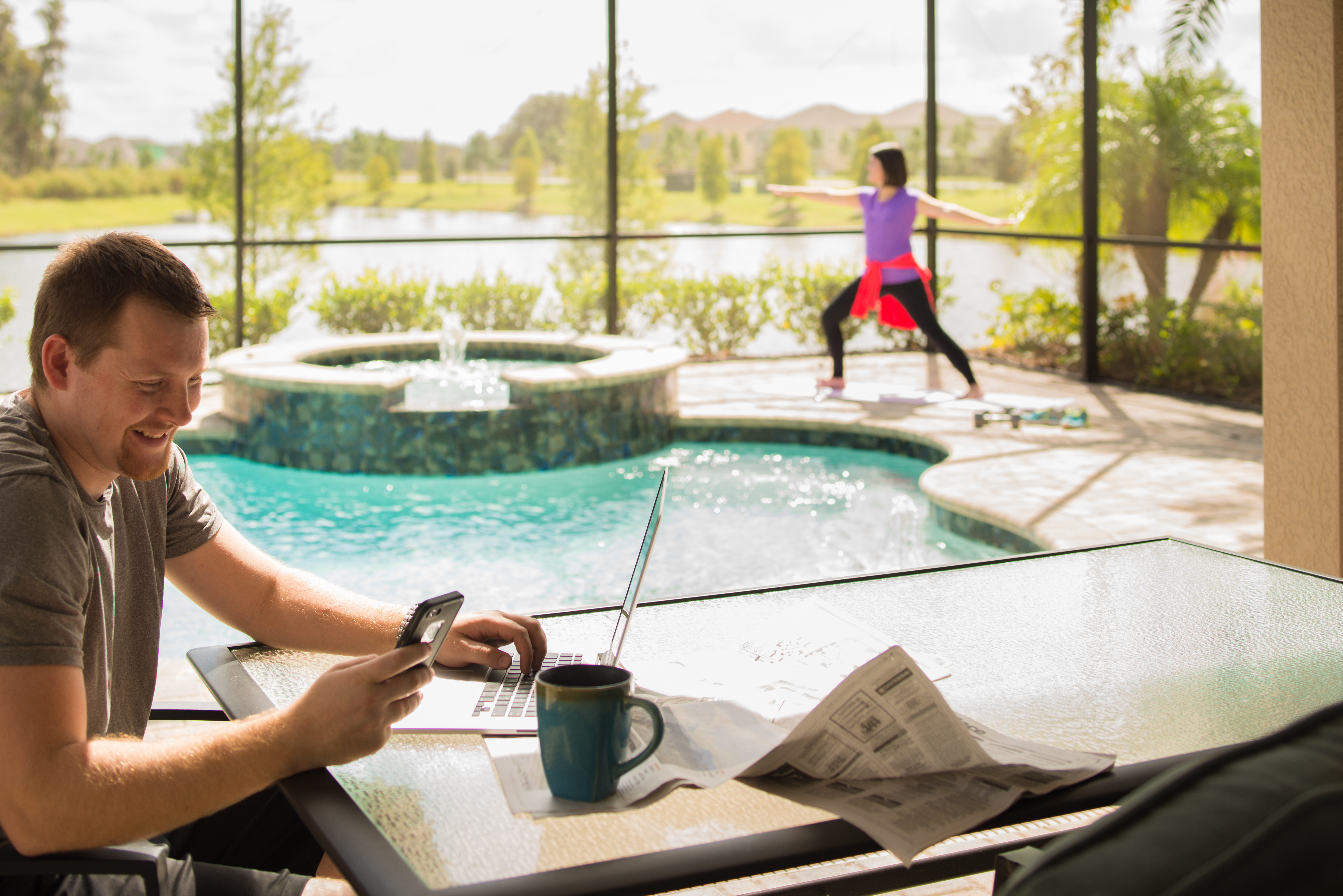 Couple Working From Home and Doing Yoga By Pool