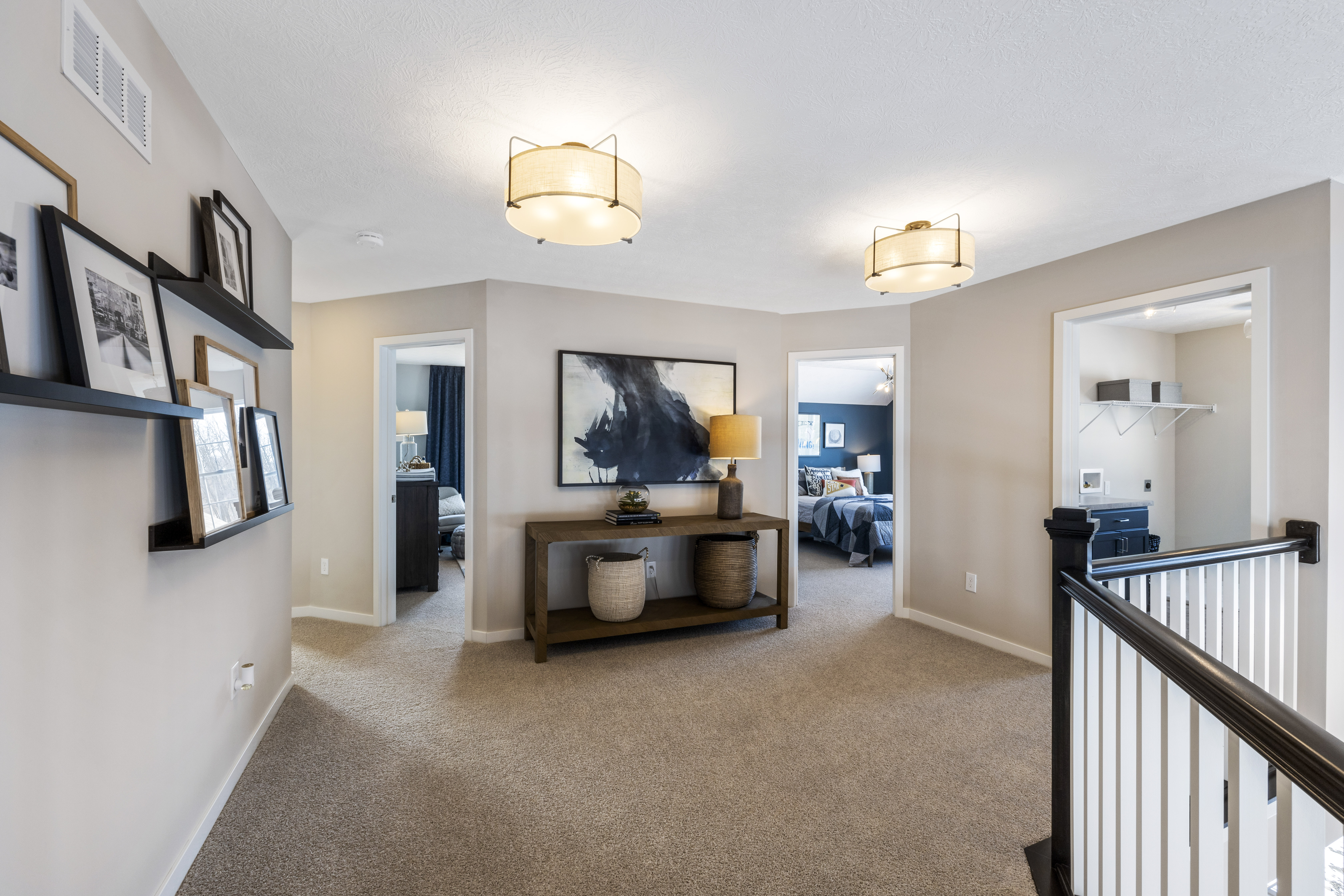 Loft with floating shelves and picture frames on the wall as well as a big console table