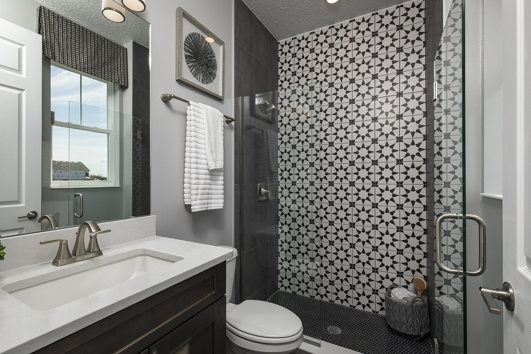 Bathroom With Black and White Patterned Tile and Light Gray Walls