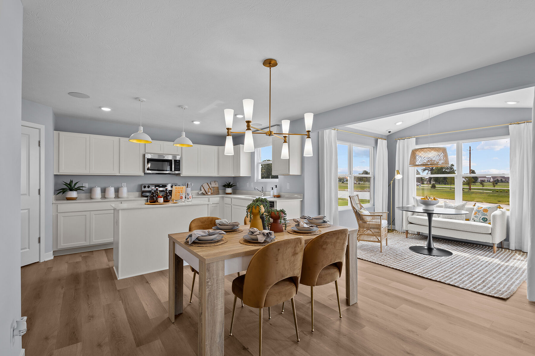 Photo of an M/I Home model kitchen and breakfast area with a gold light fixture