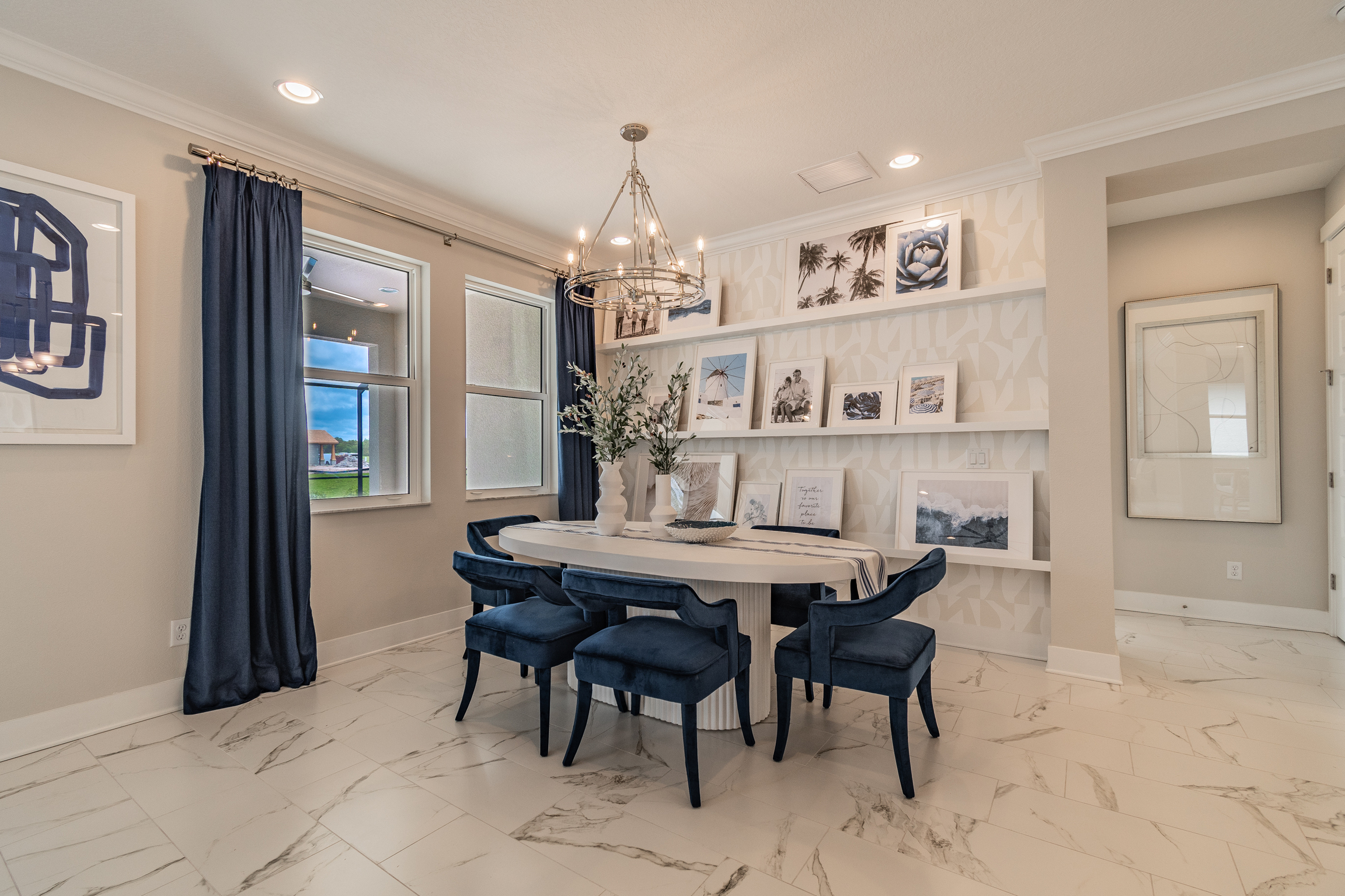 [Dining Room With Blue Accents and Gallery Pictures on Shelves]