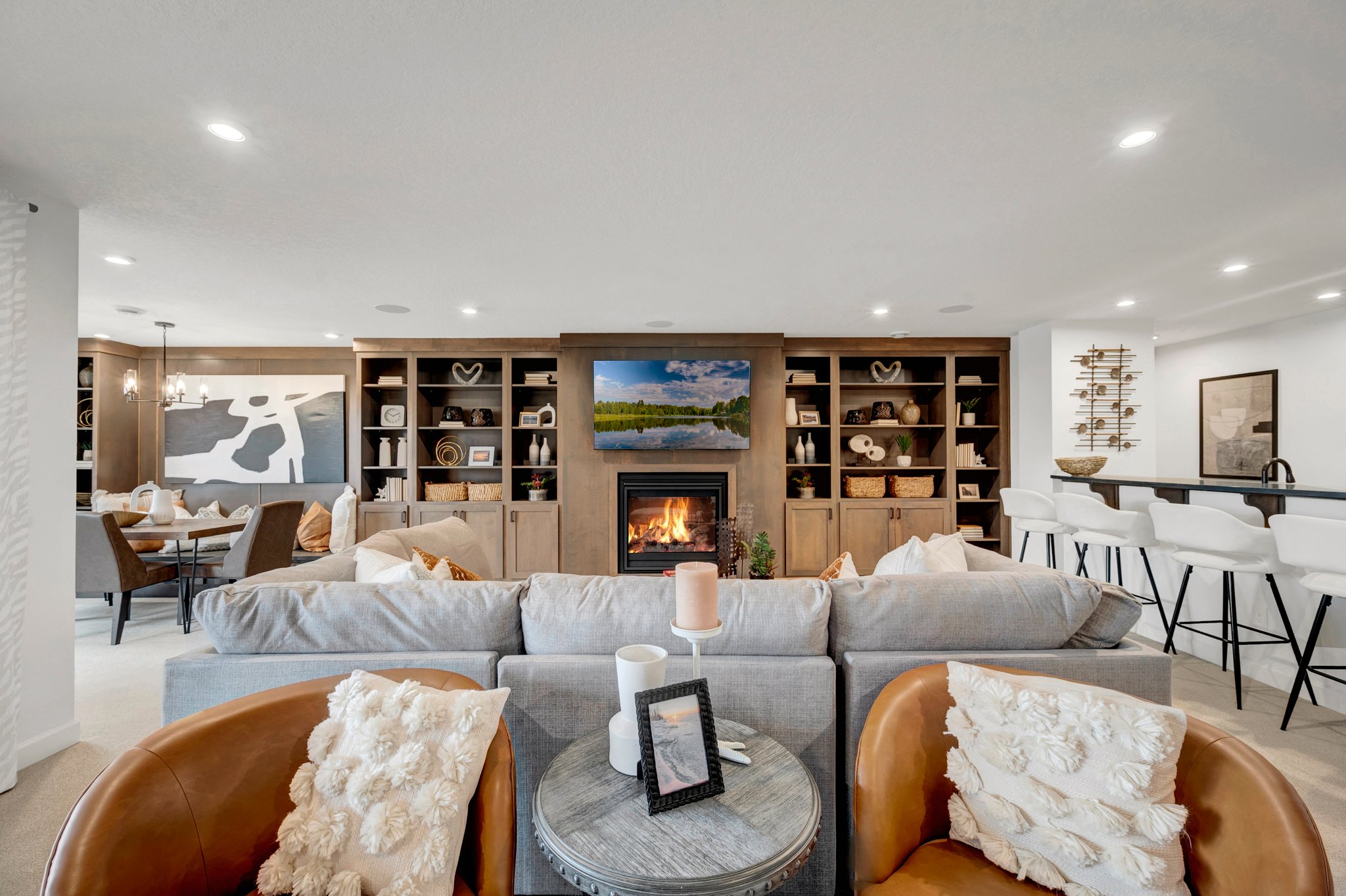 Large Basement With Several Seating Areas and a Fireplace in an Entertainment Center