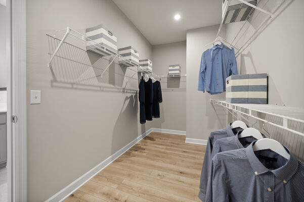 Photo of a large walk-in closet with shelves and clothes hanging