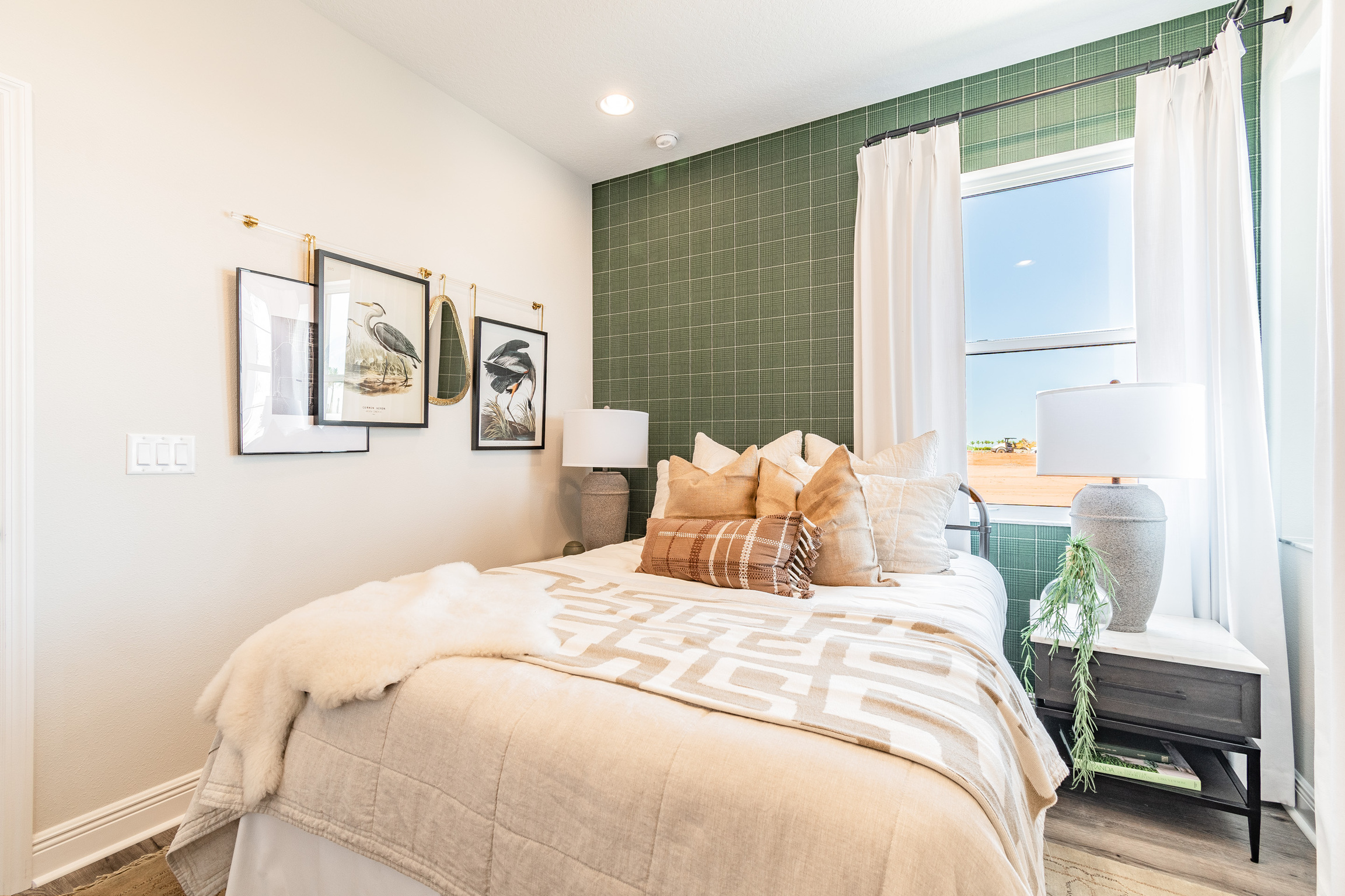[Green and Beige Bedroom With Hanging Artwork on Wall]