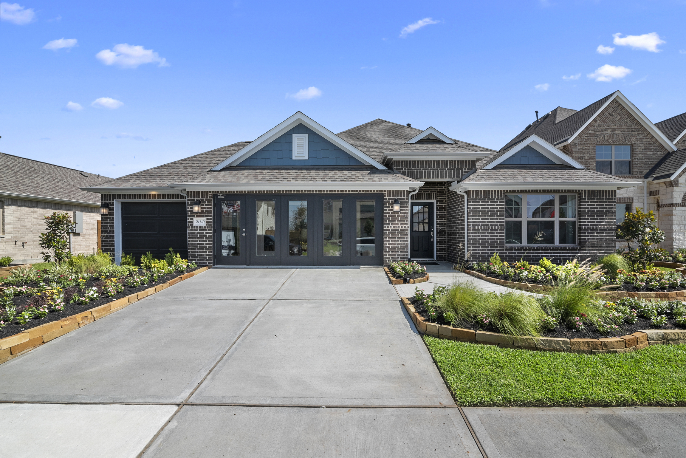 Photo of a model home with ornamenal grass landscaping