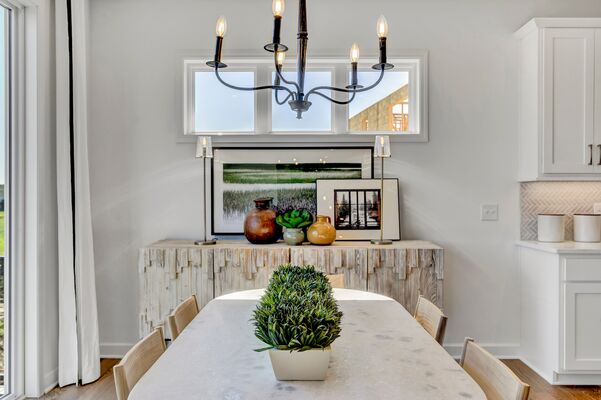 Image of a dining room with a buffet table decorated with framed art and pottery