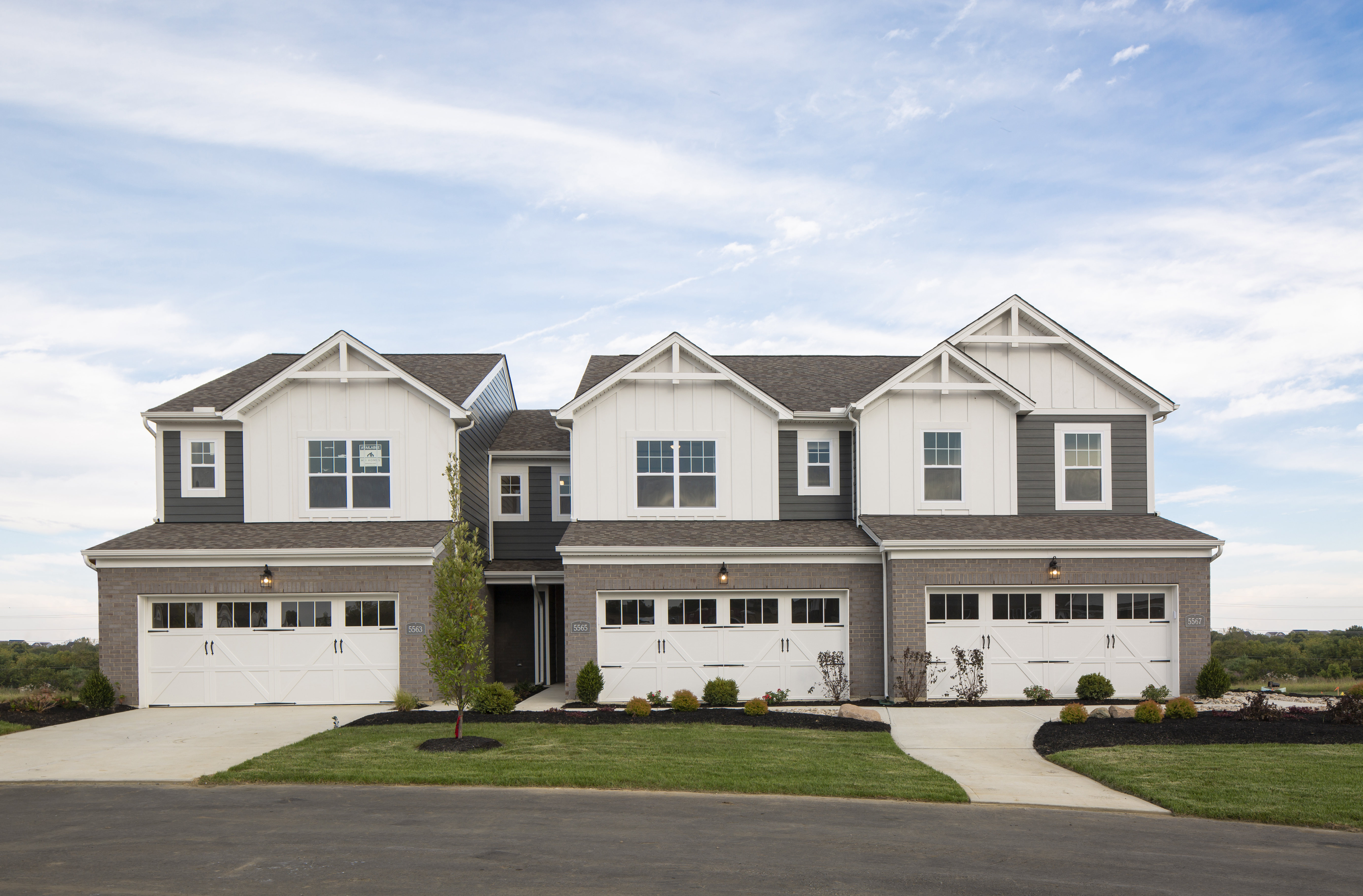 Townhome Front Exterior With White Siding and 3 Connected Units