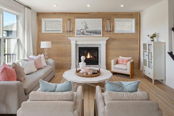 Image of a bright living room with a gas fireplace, 3 chairs, a coffee table, and a couch