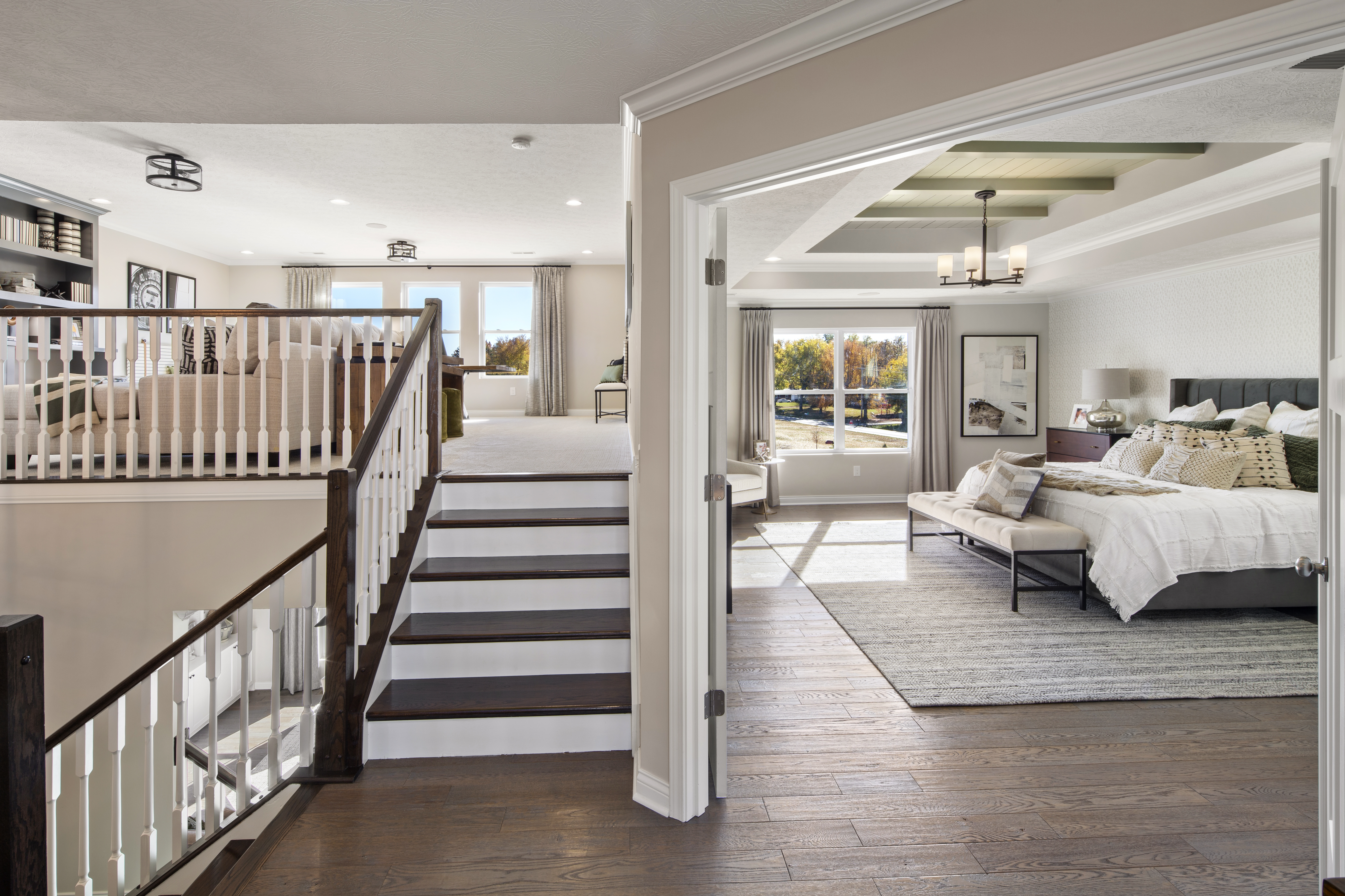 [A few wood stairs leading up to a carpeted loft space in a bright home]