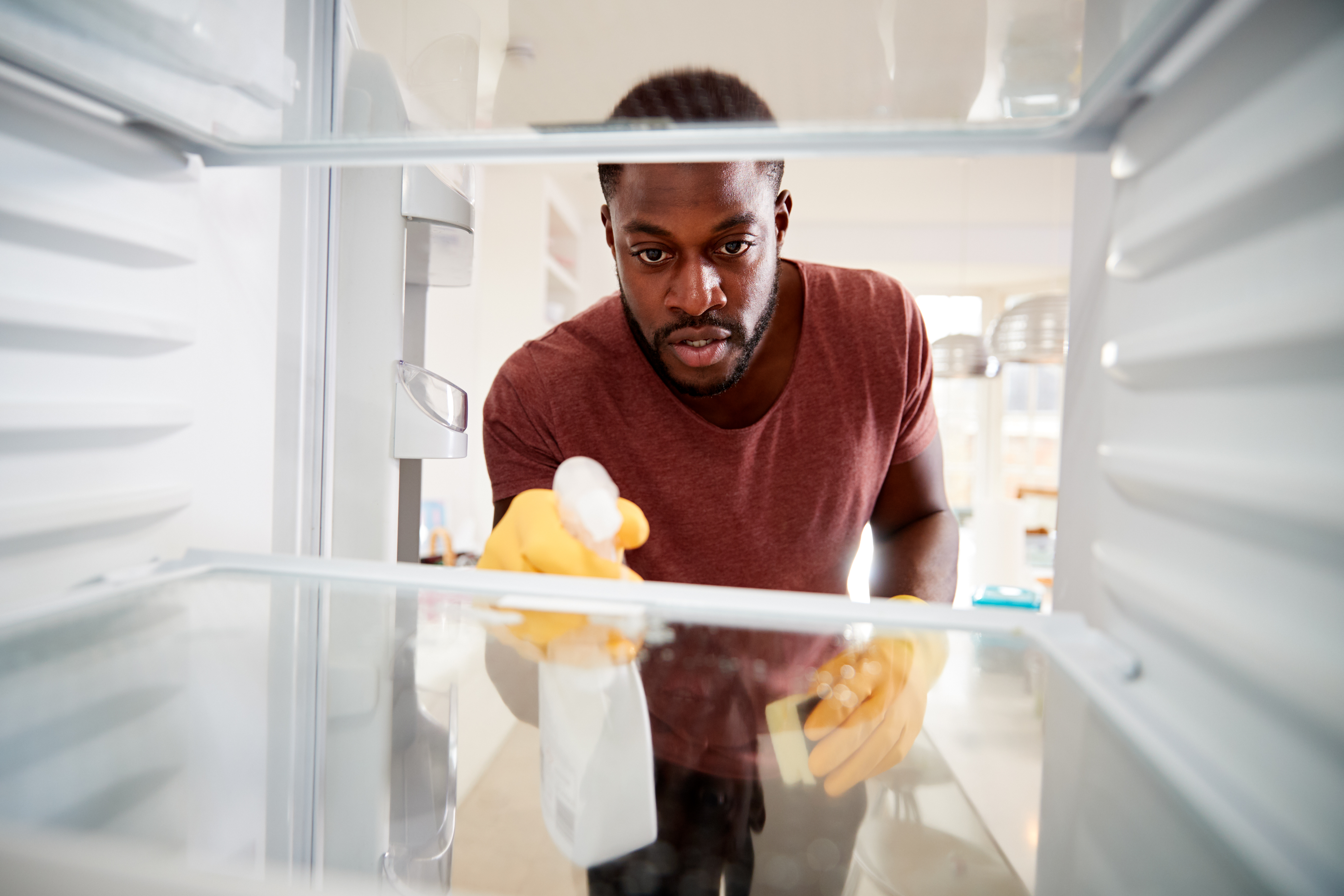 Man Cleaning Inside of Refrigerator