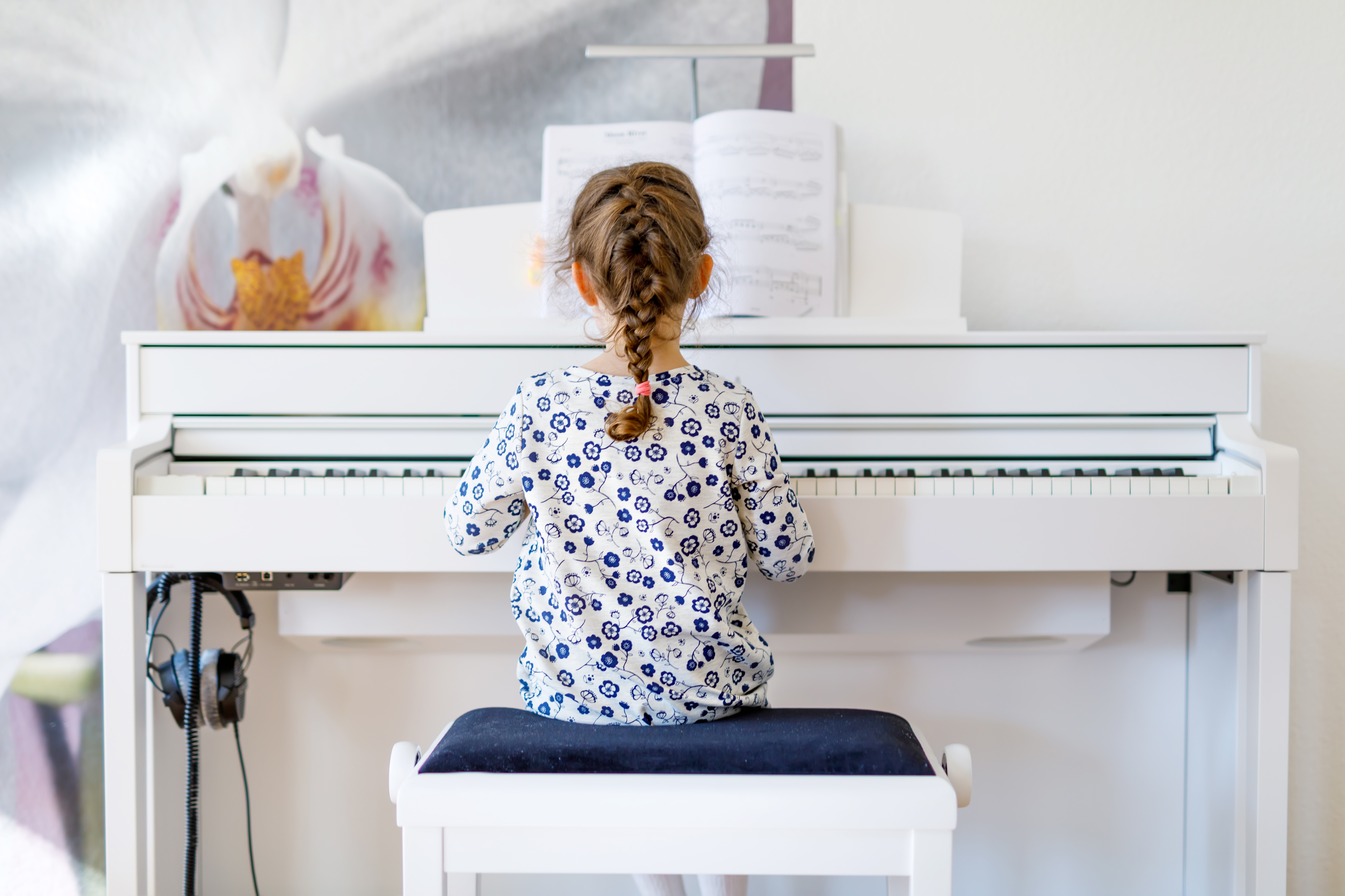 Girl playing piano with back to camera