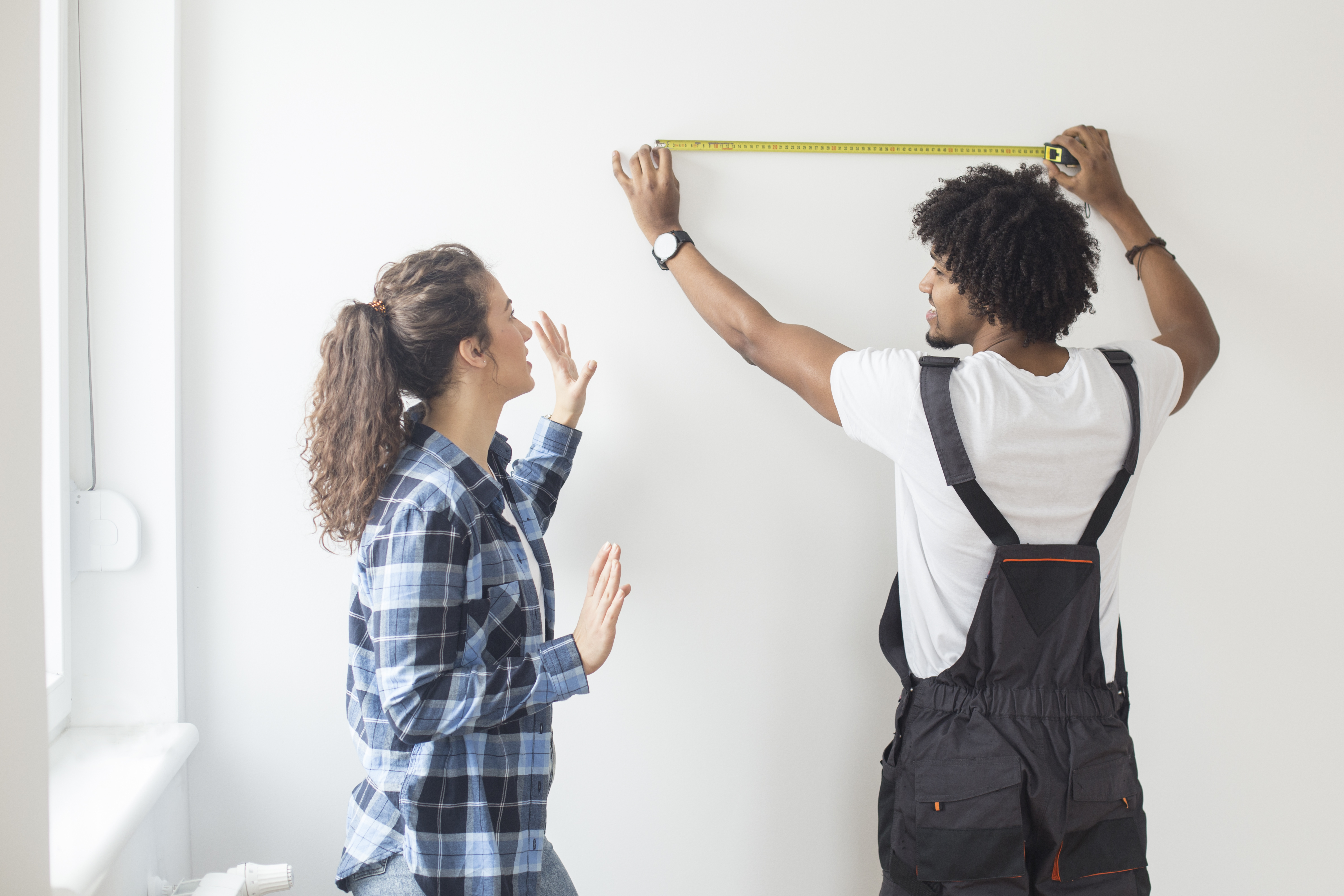 [Couple Measuring a Spot on a Wall]