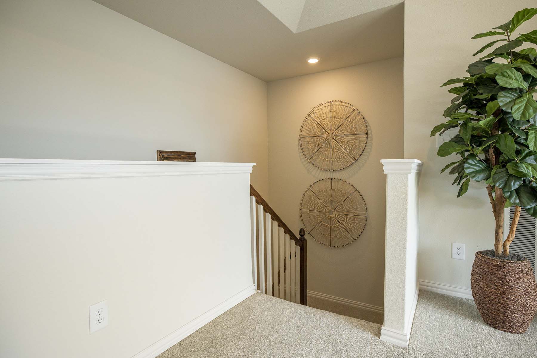 A staircase with circular woven art on one wall