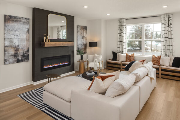 Image of a living room with a white sectional, a black accent wall, and an electric fireplace
