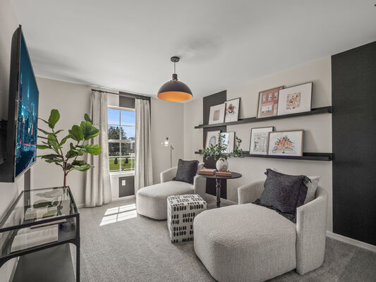 Image of a multipurpose room with floating wall shelves displaying framed art