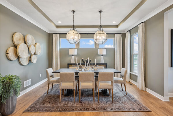 Image of a dining room with sculptures on the table and a large, tree-like piece hanging on the wall